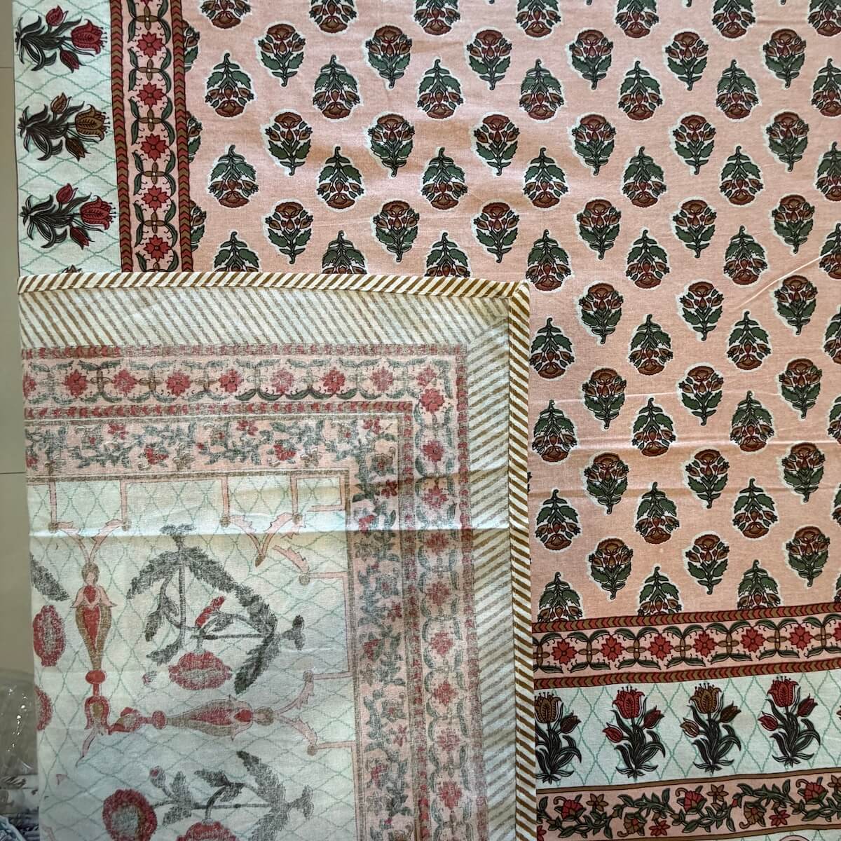 Close up of peach white Jaipur boota floral hand block print pattern on 100% cotton bed sheet