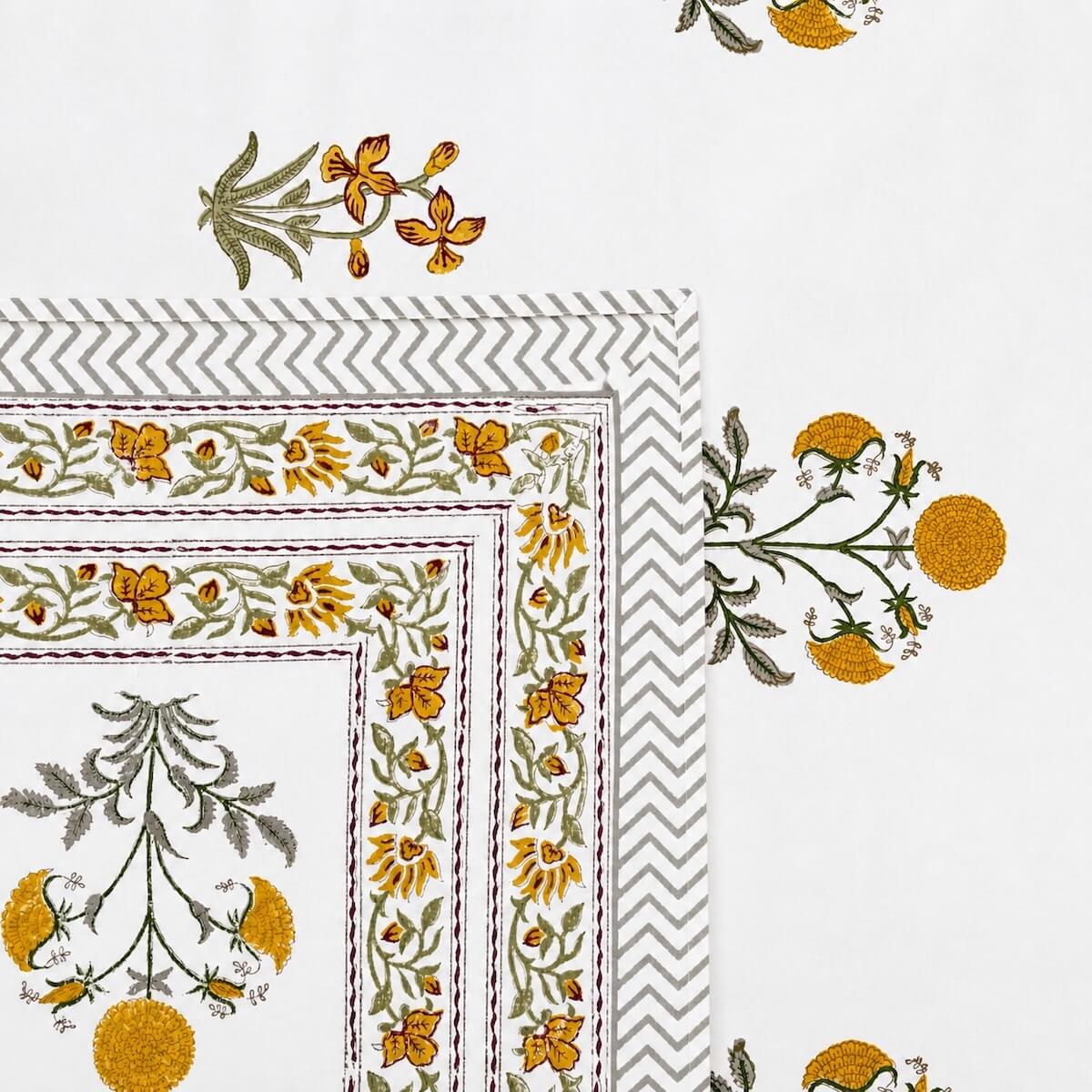 Close up of white yellow marigold pink floral hand block print pattern on 100% cotton bed sheet