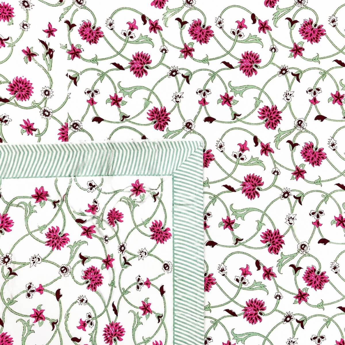 Close up of white pink jaal vine floral hand block print pattern on 100% cotton bed sheet